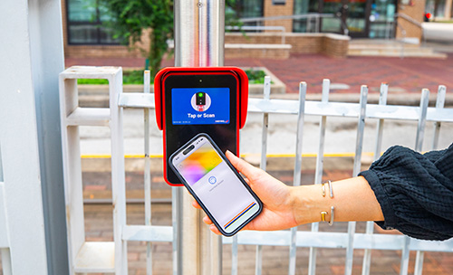 Phone tapped on a fare validator that displays a mobile wallet stored credit card